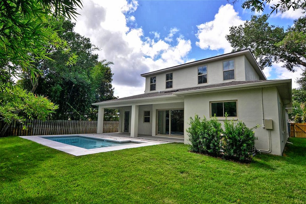 Trendy backyard concrete paver and l-shaped pool photo in Orlando