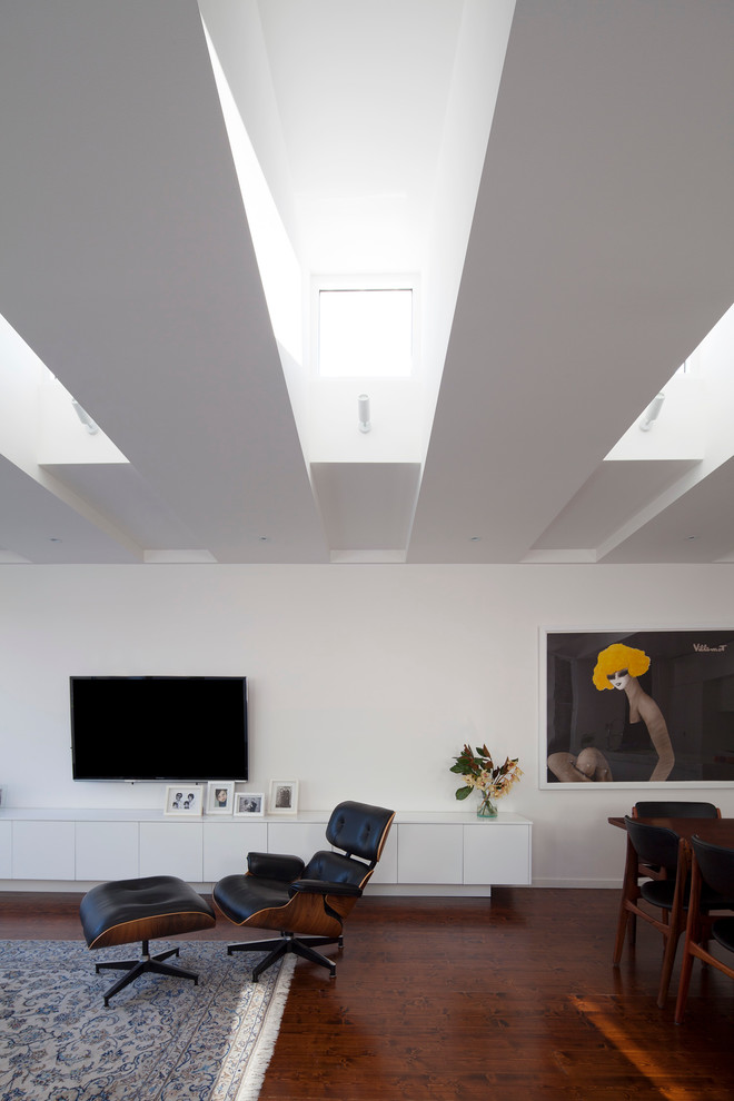 This is an example of a contemporary living room in Melbourne with white walls and medium hardwood floors.