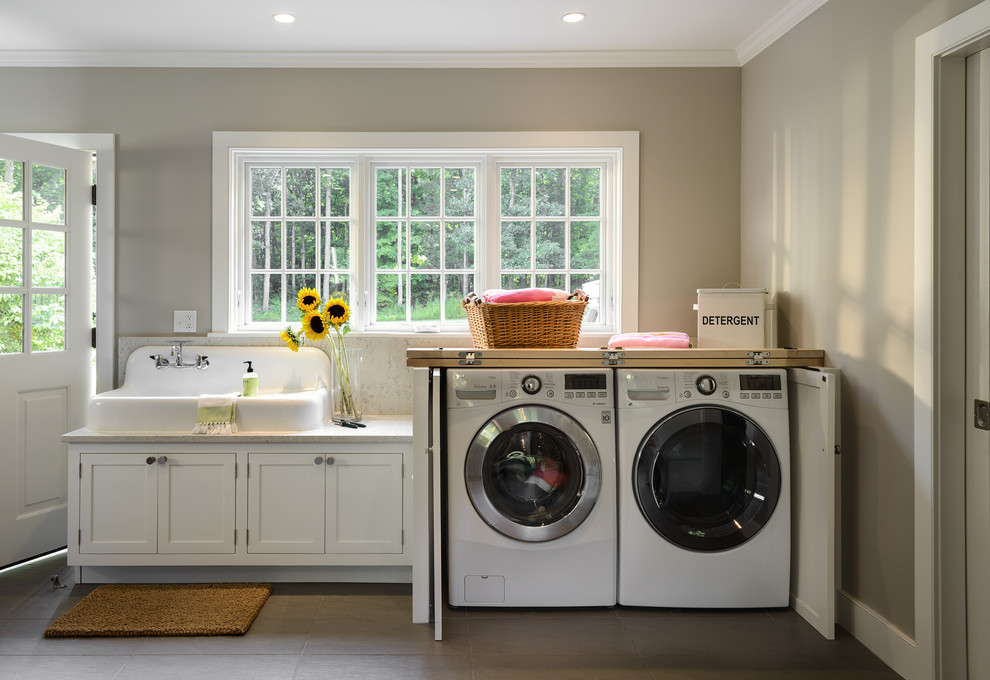 This is an example of a mid-sized country utility room in New York with a farmhouse sink, white cabinets, marble benchtops, beige walls, ceramic floors and recessed-panel cabinets.
