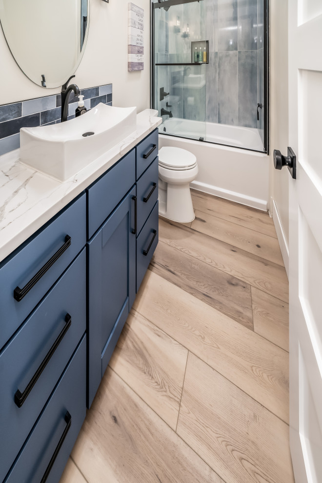 Example of a mid-sized 1950s 3/4 blue tile and ceramic tile vinyl floor, beige floor, single-sink and vaulted ceiling bathroom design in Wichita with beaded inset cabinets, white cabinets, a one-piece toilet, white walls, a drop-in sink, marble countertops, white countertops and a floating vanity