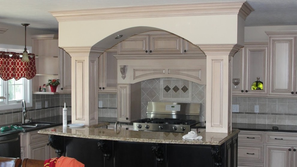 Example of a mid-sized l-shaped medium tone wood floor open concept kitchen design with light wood cabinets, granite countertops, beige backsplash, ceramic backsplash, stainless steel appliances and an island