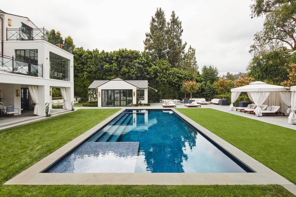 Ejemplo de casa de la piscina y piscina alargada clásica grande rectangular en patio trasero