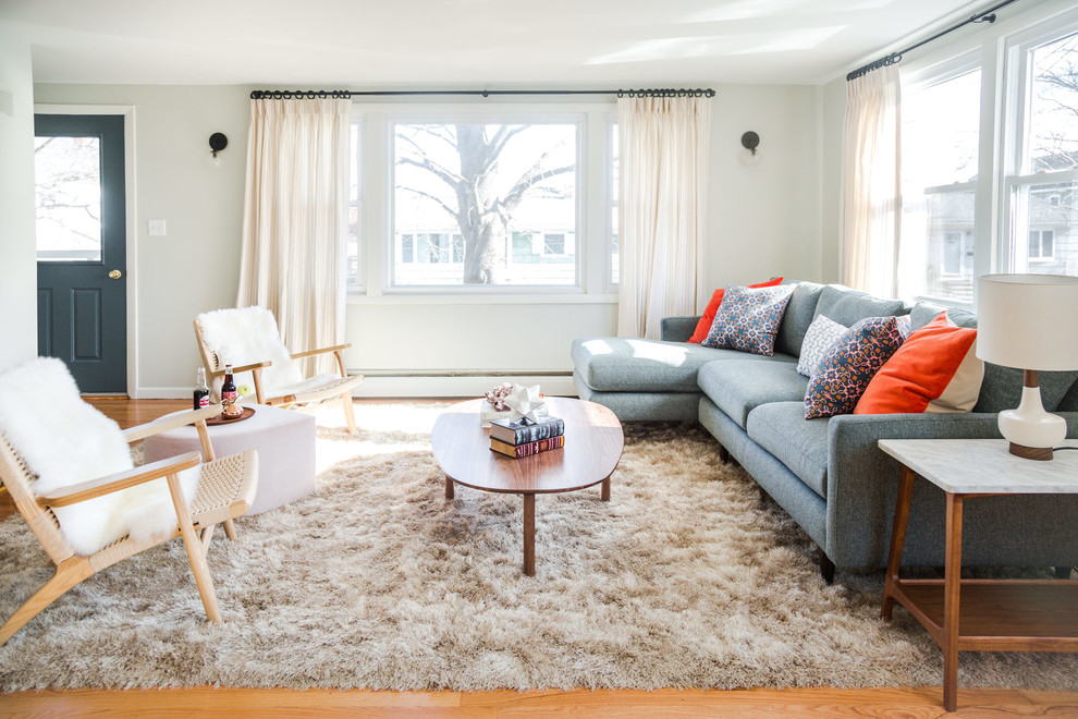 This is an example of a mid-sized scandinavian formal open concept living room in Portland Maine with grey walls, medium hardwood floors, no tv and brown floor.