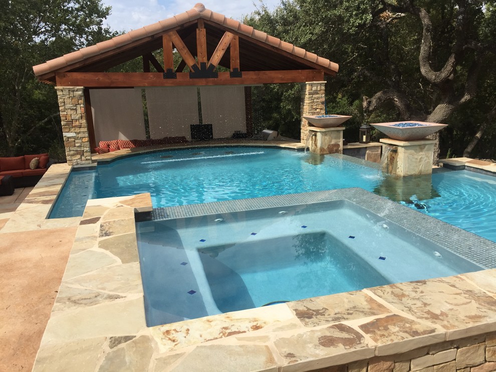 Hot tub - large rustic backyard custom-shaped infinity hot tub idea in Austin with decking