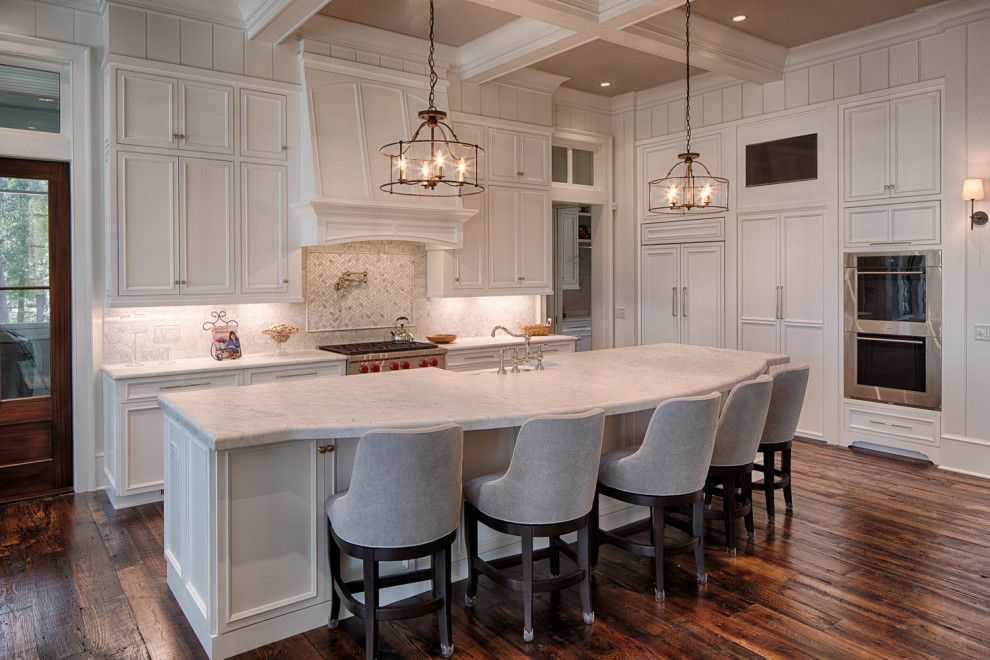 Design ideas for a transitional l-shaped kitchen in Atlanta with a farmhouse sink, recessed-panel cabinets, white cabinets, grey splashback, marble splashback, stainless steel appliances, dark hardwood floors, with island, brown floor and white benchtop.