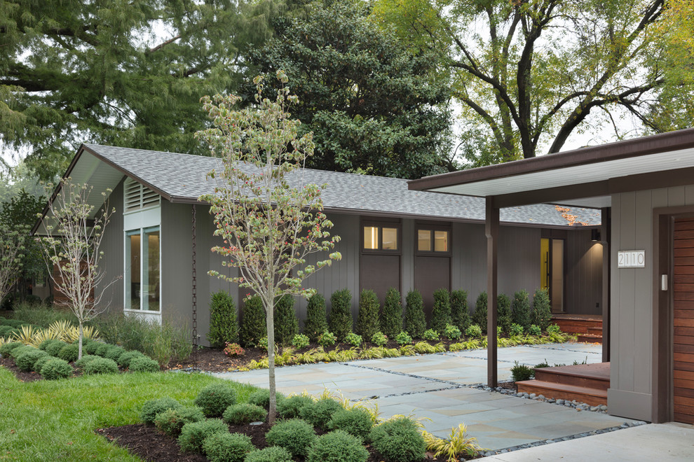 This is an example of a mid-sized midcentury front yard garden in Kansas City with natural stone pavers.