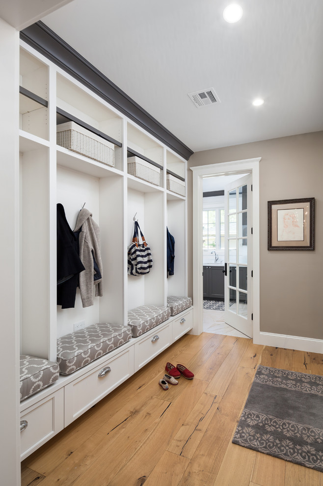 This is an example of a mid-sized transitional mudroom in Phoenix with beige walls and light hardwood floors.