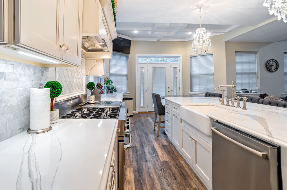 Example of a large transitional single-wall medium tone wood floor and brown floor eat-in kitchen design in Philadelphia with a farmhouse sink, shaker cabinets, white cabinets, quartz countertops, gray backsplash, porcelain backsplash, stainless steel appliances, an island and white countertops