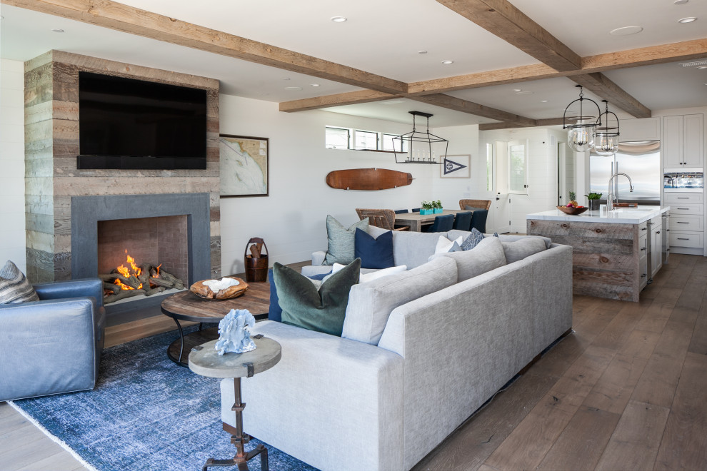 Design ideas for a mid-sized beach style open concept living room in Orange County with white walls, medium hardwood floors, a standard fireplace, a stone fireplace surround and a wall-mounted tv.