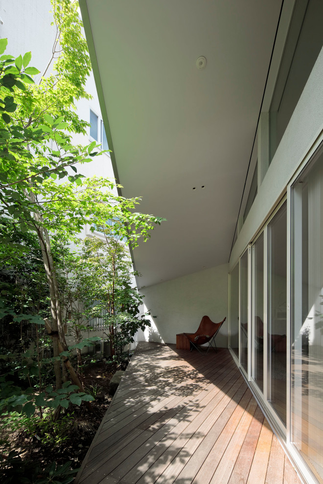 Ejemplo de terraza minimalista pequeña en patio delantero y anexo de casas con entablado