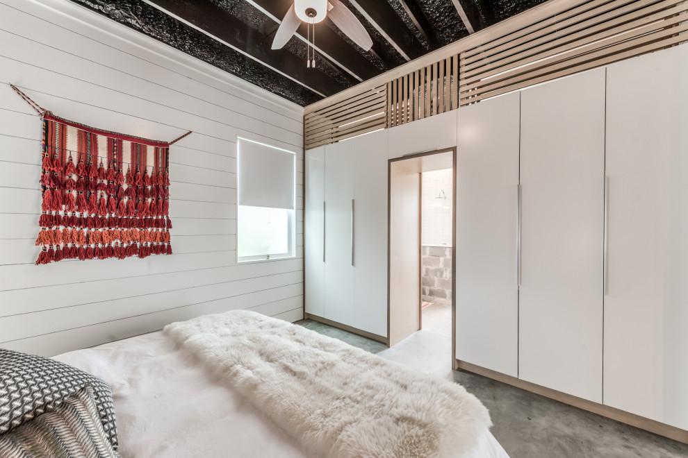 Aménagement d'une chambre parentale éclectique de taille moyenne avec un mur blanc, sol en béton ciré, un sol gris et un plafond en lambris de bois.
