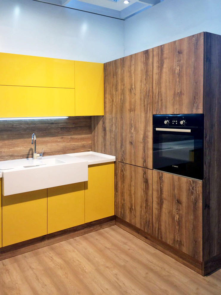 Photo of an u-shaped eat-in kitchen in Moscow with yellow cabinets and solid surface benchtops.