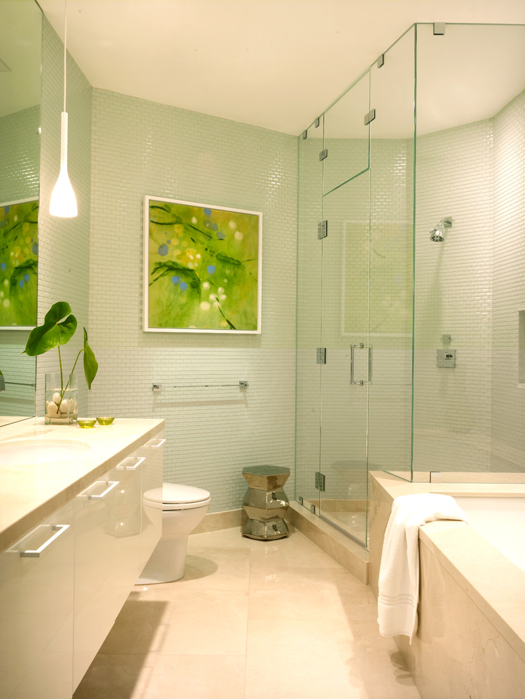 This is an example of a beach style bathroom in Los Angeles with flat-panel cabinets, white cabinets, an undermount tub, a corner shower, green tile and mosaic tile.