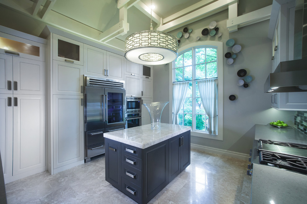 Kitchen - large transitional u-shaped porcelain tile and beige floor kitchen idea with raised-panel cabinets, white cabinets, gray backsplash, glass tile backsplash, stainless steel appliances, an island, an undermount sink and solid surface countertops