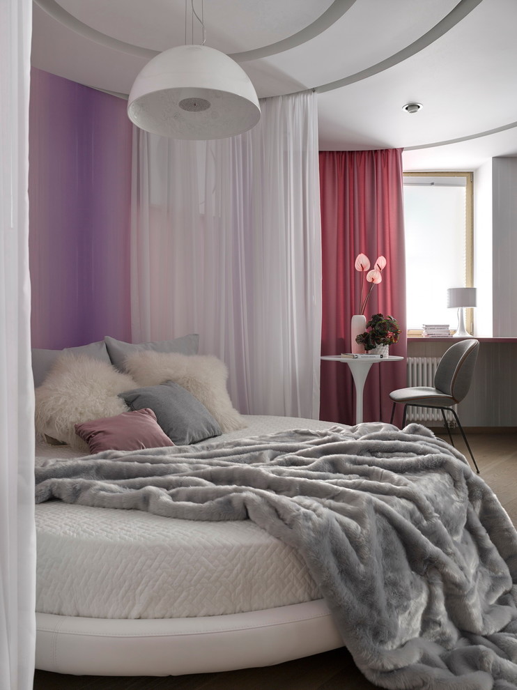 This is an example of a large contemporary kids' room for girls in Moscow with pink walls and medium hardwood floors.
