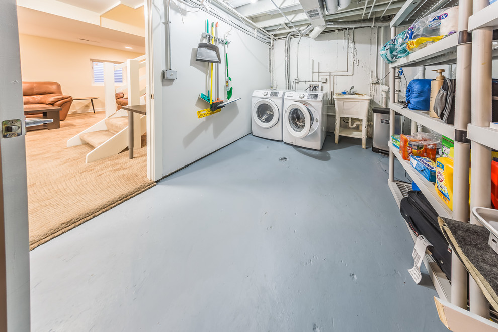 Mid-sized contemporary galley utility room in Chicago with an utility sink, white walls, concrete floors, a side-by-side washer and dryer and grey floor.