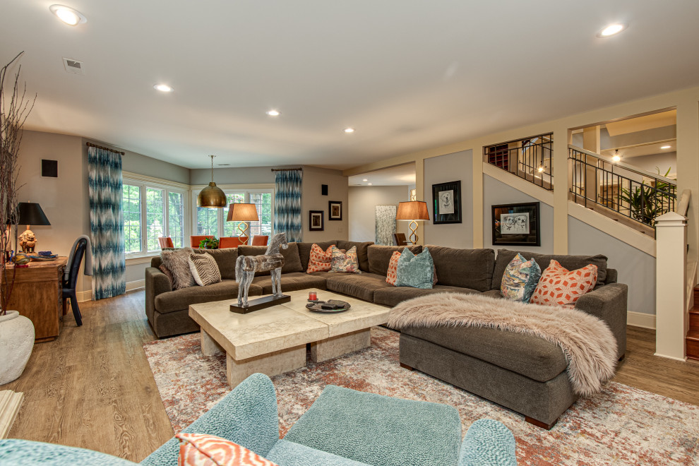 Foto di un soggiorno classico aperto con pareti grigie, pavimento in legno massello medio e pavimento marrone