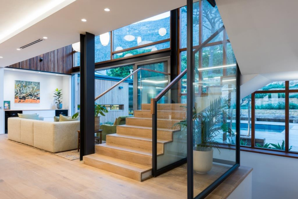 Mid-sized midcentury u-shaped staircase in Other with wood risers and glass railing.