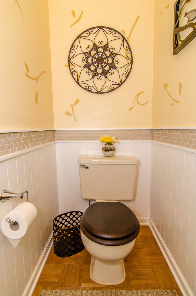 Inspiration for a mid-sized transitional powder room in Philadelphia with a drop-in sink, a one-piece toilet, beige tile, ceramic tile, yellow walls and medium hardwood floors.