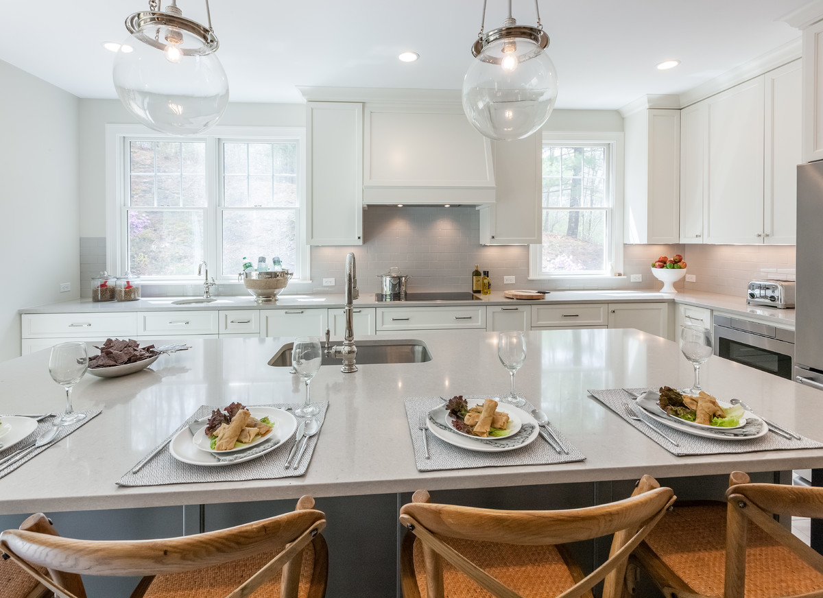 Transitional kitchen photo in Boston with an undermount sink, gray cabinets, quartzite countertops, subway tile backsplash, stainless steel appliances and an island