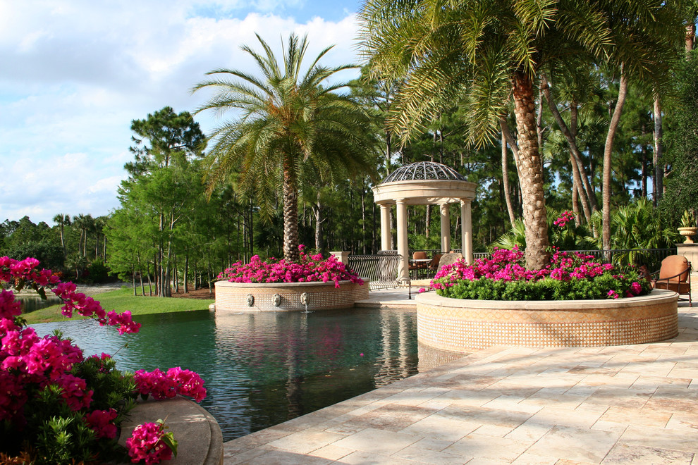 Expansive traditional front yard full sun formal garden in Miami with a garden path and natural stone pavers for spring.