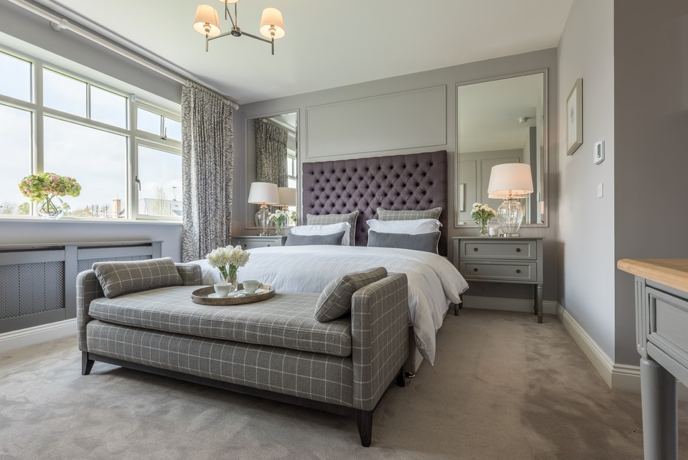 Photo of a large transitional master bedroom in Dublin with grey walls, carpet, no fireplace and grey floor.