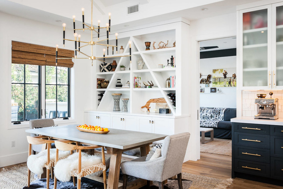 Inspiration for an eclectic dining room in Orange County with white walls, medium hardwood floors and brown floor.