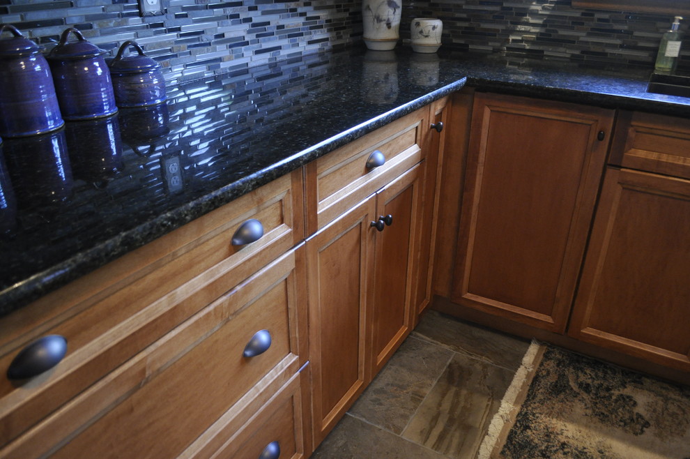 Inspiration for a mid-sized rustic l-shaped kitchen remodel in Toronto with an undermount sink, medium tone wood cabinets, granite countertops, blue backsplash, stainless steel appliances and no island