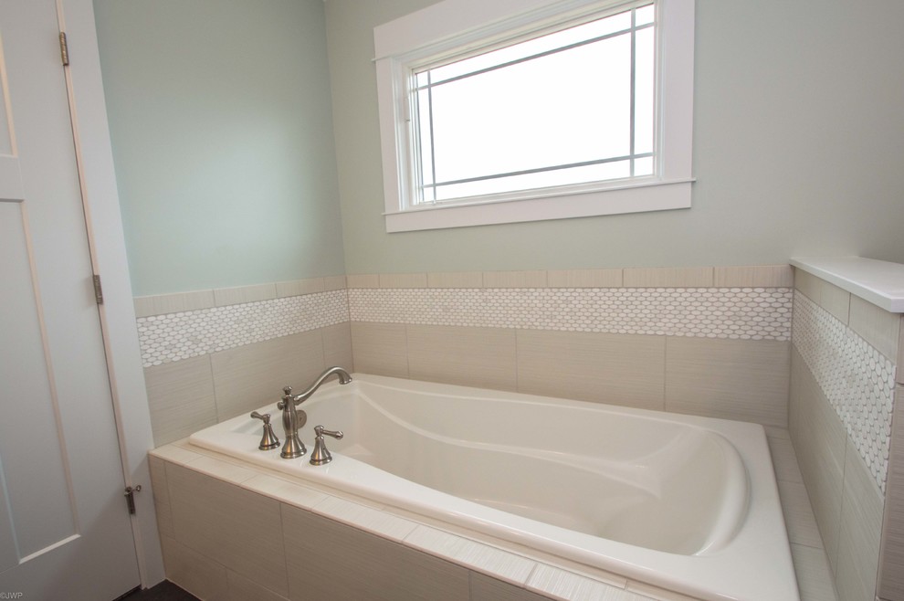 Example of a mid-sized transitional 3/4 gray tile and porcelain tile porcelain tile and black floor drop-in bathtub design in Chicago with shaker cabinets, gray cabinets, gray walls, an undermount sink, solid surface countertops and a hinged shower door