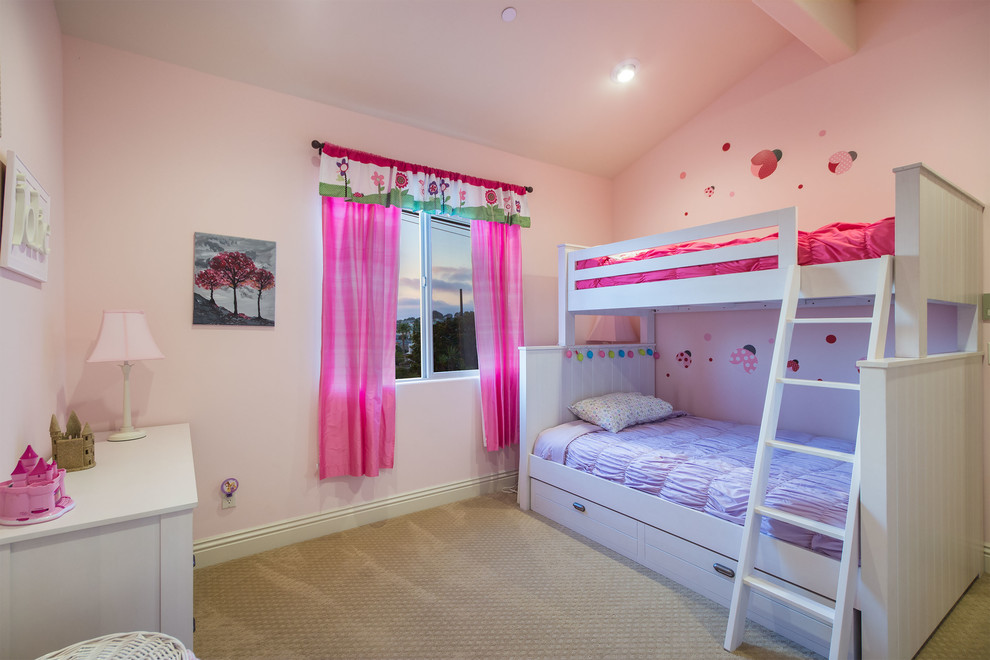 This is an example of a mid-sized mediterranean kids' bedroom for kids 4-10 years old and girls in Los Angeles with pink walls and carpet.