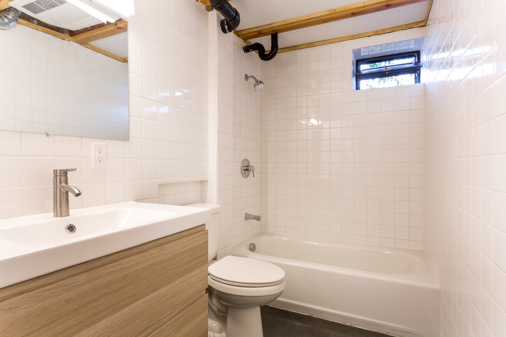 Inspiration for a mid-sized mid-century modern 3/4 white tile and ceramic tile concrete floor, single-sink and exposed beam drop-in bathtub remodel in Seattle with flat-panel cabinets, medium tone wood cabinets, an integrated sink, white countertops and a floating vanity