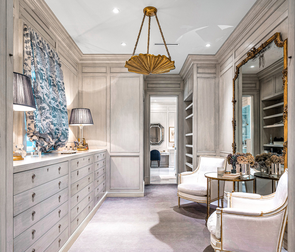 Inspiration for an expansive tropical women's dressing room in Miami with flat-panel cabinets, light wood cabinets, carpet and blue floor.