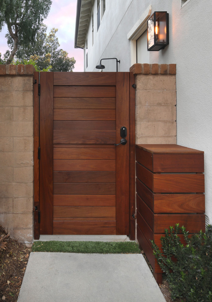This is an example of a mid-sized contemporary side yard partial sun garden for summer in Orange County with with a gate and concrete pavers.