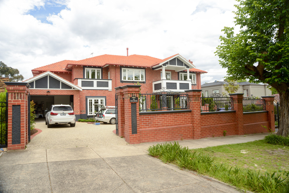 Photo of an expansive arts and crafts two-storey brick red house exterior in Melbourne with a gable roof and a tile roof.