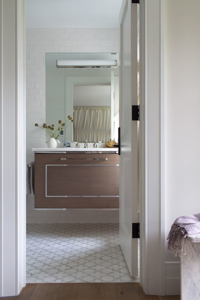 Bathroom - mid-sized transitional white tile and ceramic tile ceramic tile and white floor bathroom idea with flat-panel cabinets, brown cabinets, an undermount sink, marble countertops and brown countertops