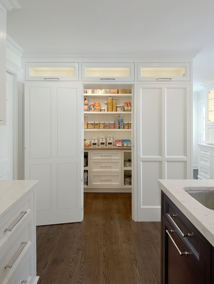 Mid-sized transitional u-shaped dark wood floor and brown floor eat-in kitchen photo in Chicago with a drop-in sink, recessed-panel cabinets, white cabinets, quartz countertops, white backsplash, quartz backsplash, stainless steel appliances, an island and white countertops