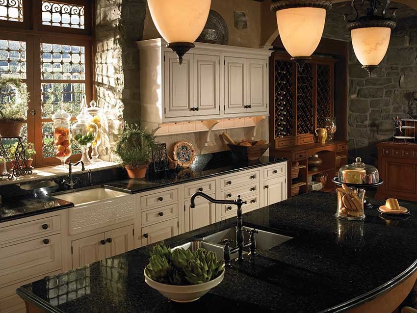 Inspiration for a mid-sized rustic l-shaped dark wood floor eat-in kitchen remodel in Jackson with a farmhouse sink, raised-panel cabinets, white cabinets, granite countertops, gray backsplash, stone tile backsplash and an island