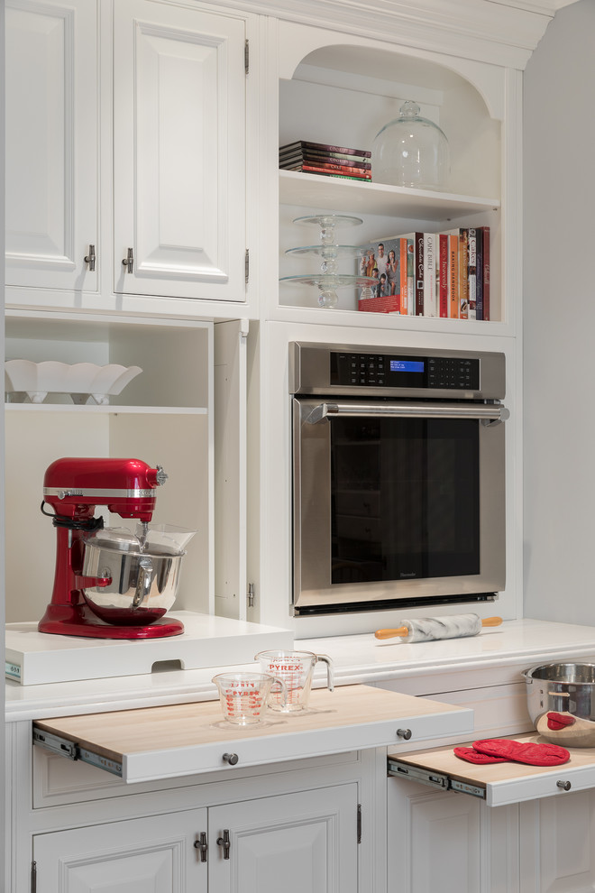 Inspiration for a huge transitional u-shaped medium tone wood floor and brown floor open concept kitchen remodel in Newark with a farmhouse sink, raised-panel cabinets, white cabinets, quartz countertops, gray backsplash, ceramic backsplash, white appliances, an island and white countertops