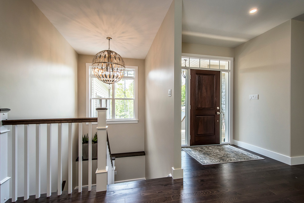 Example of a mid-sized transitional dark wood floor and brown floor front door design with beige walls and a dark wood front door