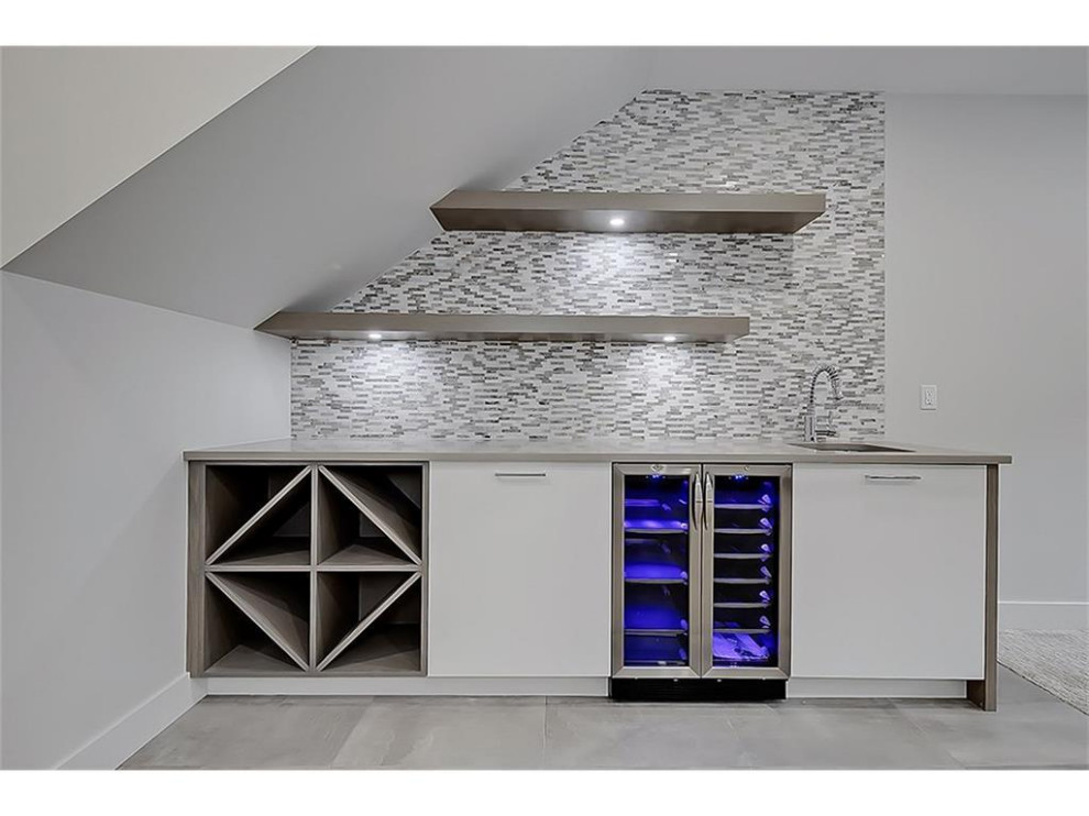 Design ideas for a mid-sized modern single-wall wet bar in Calgary with an undermount sink, flat-panel cabinets, white cabinets, quartz benchtops, multi-coloured splashback, cement tile splashback, ceramic floors, grey floor and grey benchtop.