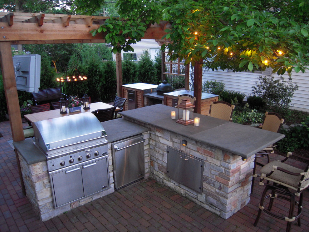 Photo of a mid-sized transitional backyard patio in Chicago with an outdoor kitchen, brick pavers and a pergola.