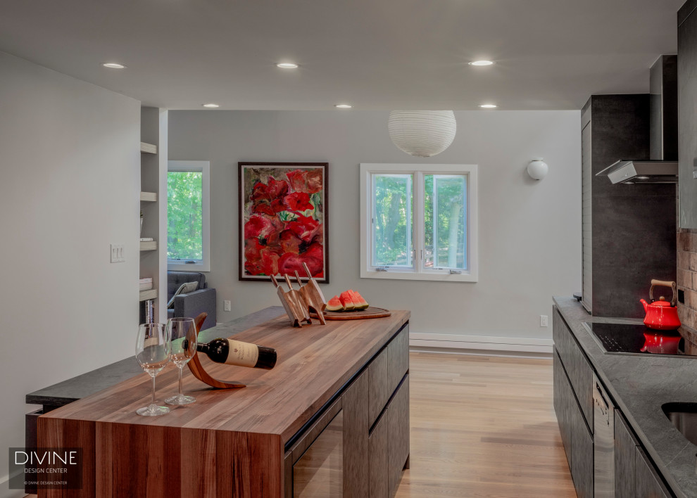 Example of a small minimalist single-wall light wood floor and brown floor eat-in kitchen design in Boston with an undermount sink, flat-panel cabinets, wood countertops, red backsplash, brick backsplash, stainless steel appliances, an island, brown countertops and gray cabinets