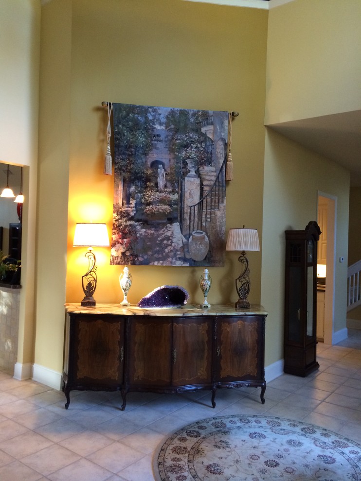 Foyer - mid-sized transitional ceramic tile foyer idea in Dallas with yellow walls and a dark wood front door