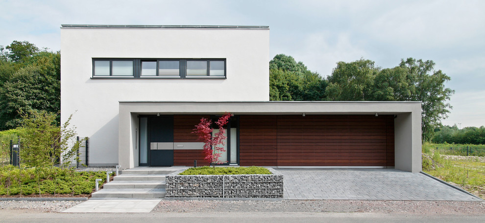 Mid-sized modern split-level white exterior in Cologne with a flat roof.