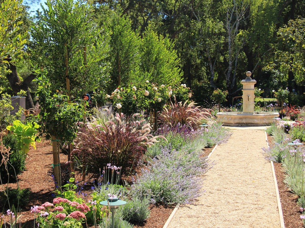 This is an example of a mediterranean full sun garden in San Francisco with a water feature and gravel.