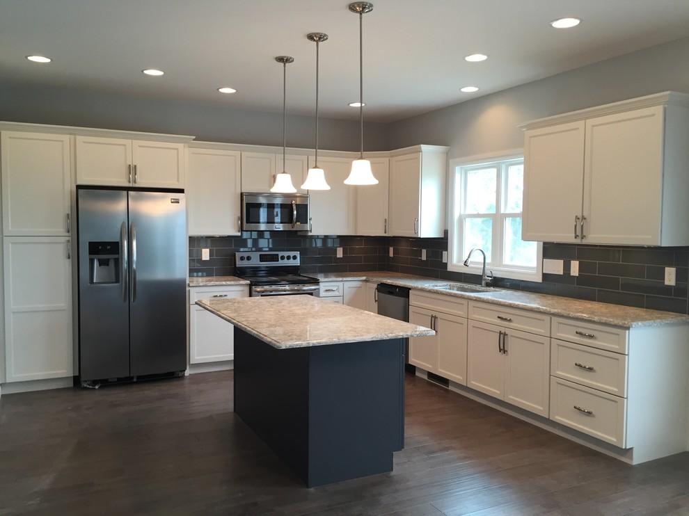 Inspiration for a large transitional l-shaped open concept kitchen remodel with an undermount sink, raised-panel cabinets, white cabinets, quartz countertops, gray backsplash, stainless steel appliances and an island