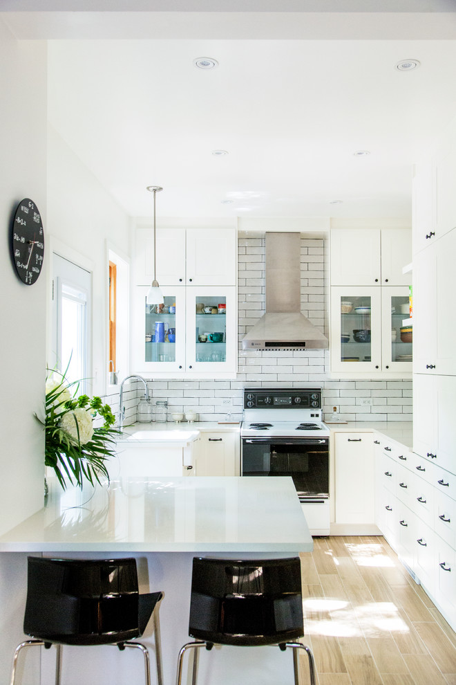 Photo of a small transitional u-shaped eat-in kitchen in Montreal with a single-bowl sink, shaker cabinets, white cabinets, quartzite benchtops, white splashback, ceramic splashback, coloured appliances, porcelain floors and with island.