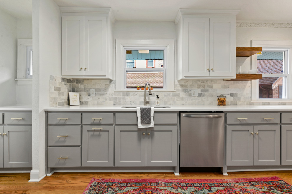 Small traditional single-wall separate kitchen in Kansas City with an undermount sink, recessed-panel cabinets, grey cabinets, quartz benchtops, grey splashback, subway tile splashback, stainless steel appliances, medium hardwood floors and white benchtop.