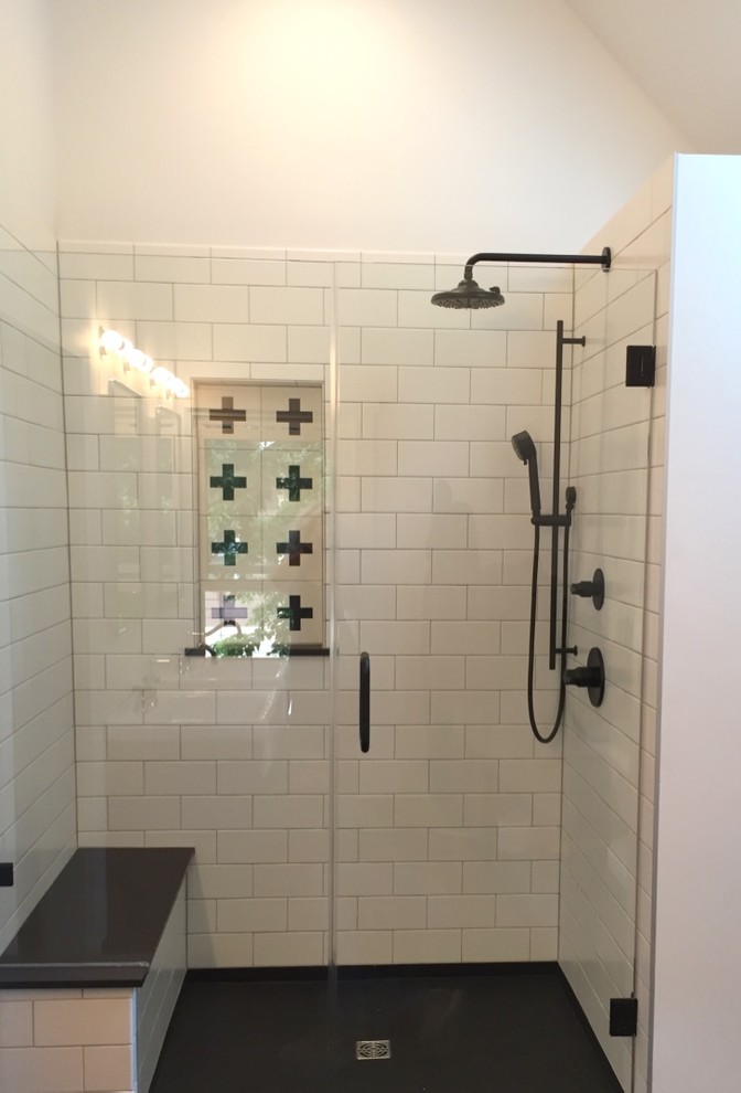 Inspiration for a mid-sized eclectic master bathroom in Milwaukee with furniture-like cabinets, medium wood cabinets, a freestanding tub, an alcove shower, a two-piece toilet, white tile, ceramic tile, white walls, ceramic floors, a console sink, black floor and a hinged shower door.