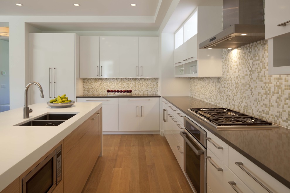 Design ideas for a contemporary kitchen in Minneapolis with a double-bowl sink, solid surface benchtops, flat-panel cabinets, white cabinets and mosaic tile splashback.